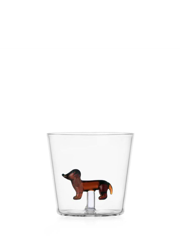 Clear glass tumbler with a dachshund figurine on a white background