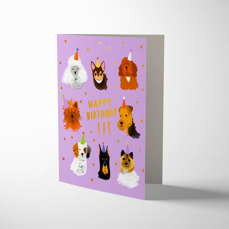 Greeting card with illustrations of dogs wearing birthday hats on a purple background