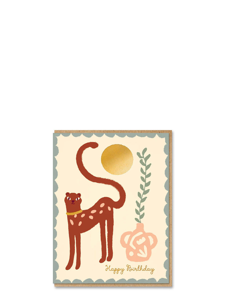 Birthday card with a stylized cat, gold circle, and floral design on a beige background.