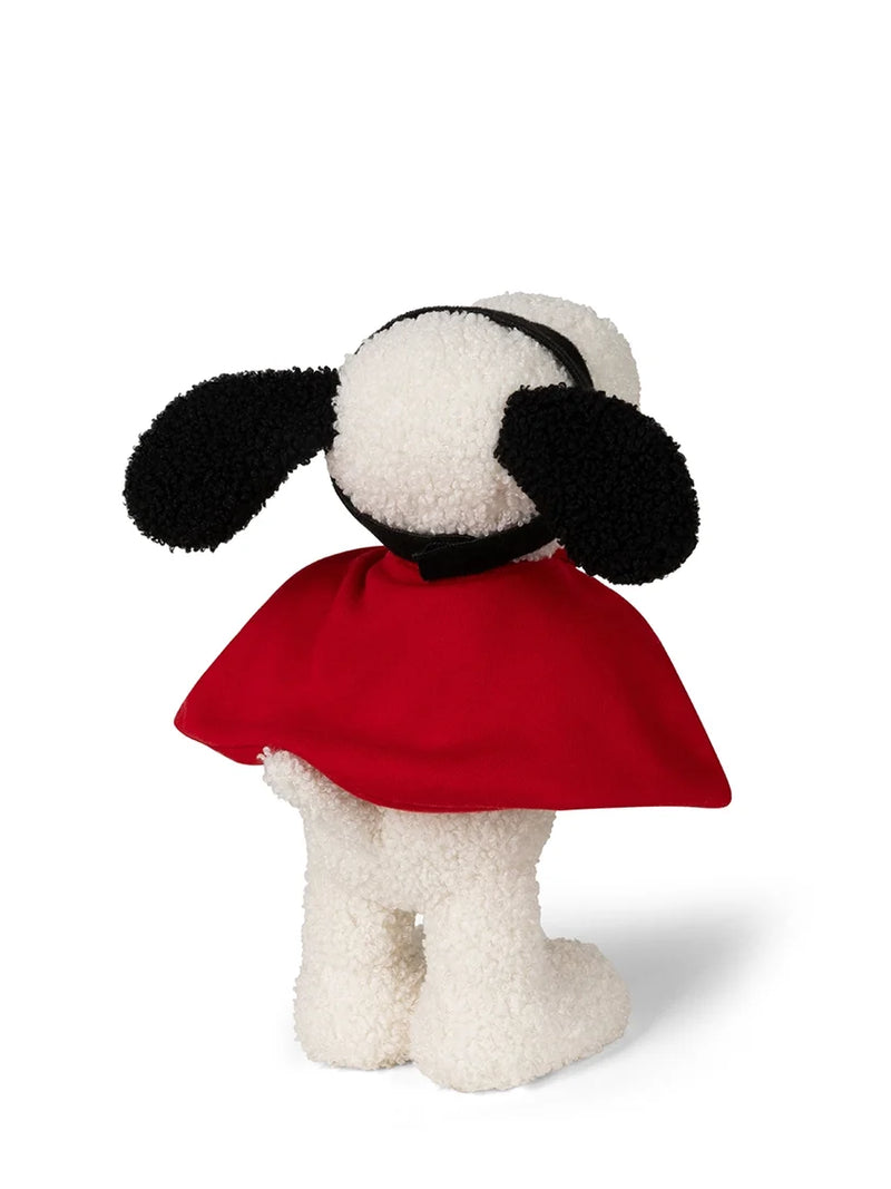 A plush dog toy shown from the back, featuring a white sherpa body, black floppy ears, and a red cape, photographed on a clean white background.