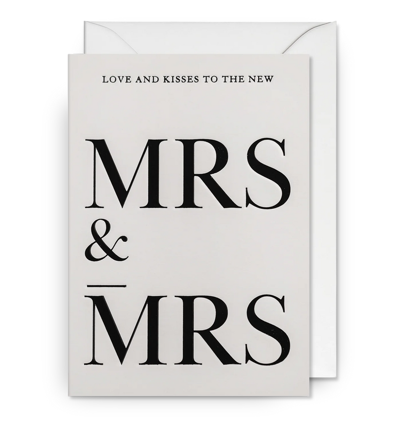 A black and white wedding card with the text 'LOVE AND KISSES TO THE NEW MRS & MRS' printed on the front. The background is white, and the text is in black.