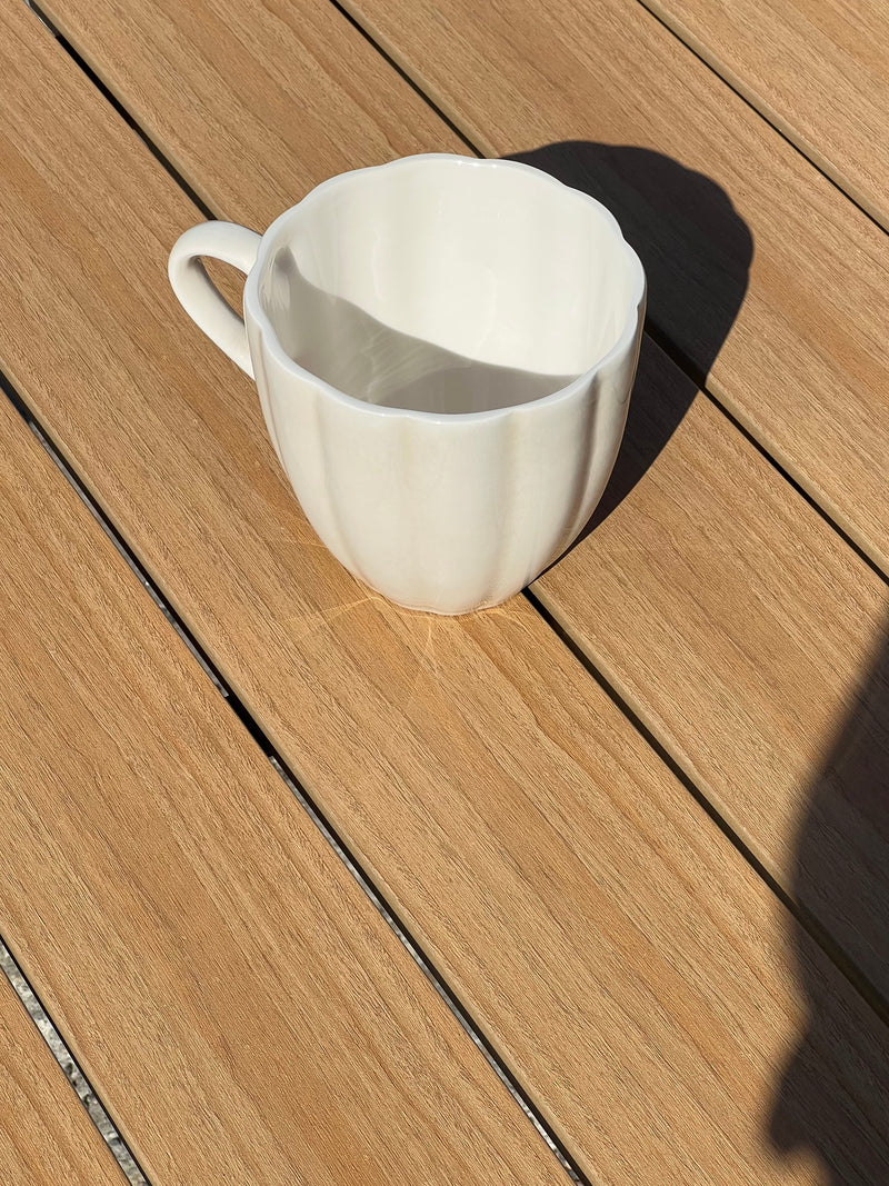 White ceramic pitcher on a wooden surface