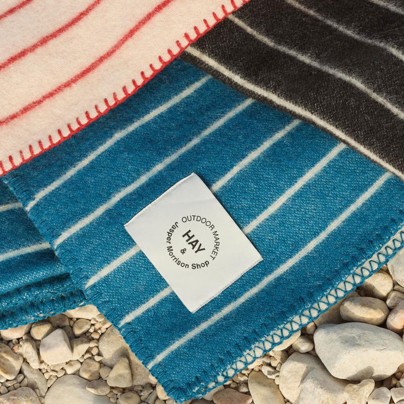 Striped fabric with a 'HAY' label on pebbles