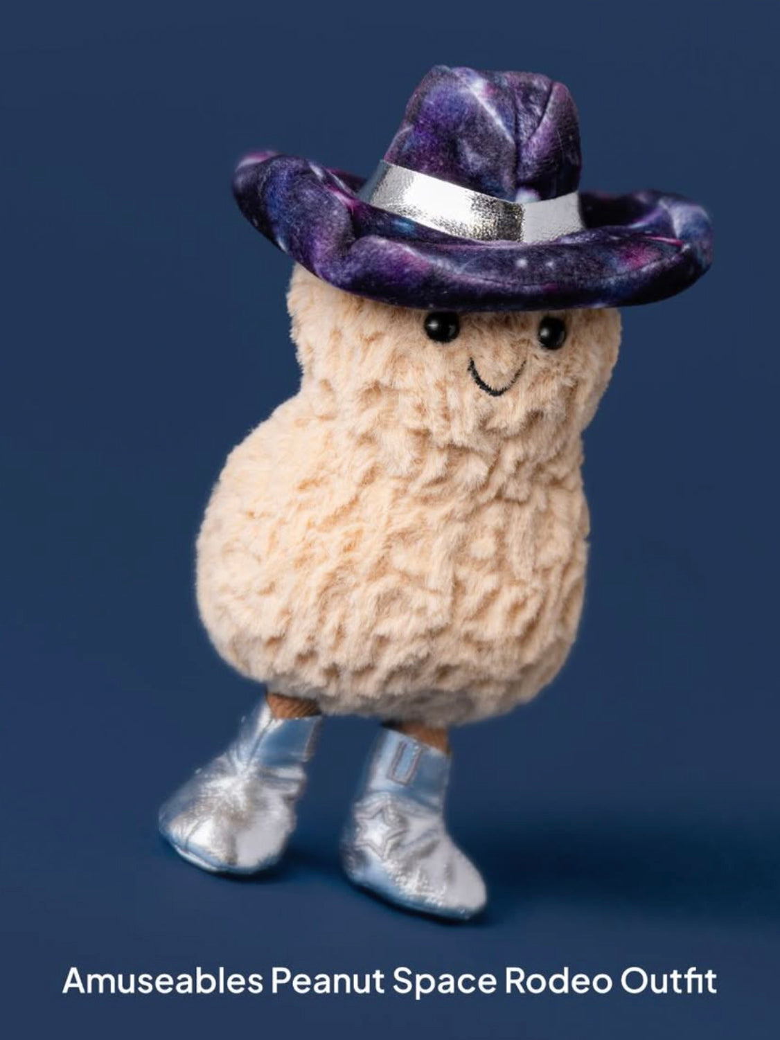 Plush toy resembling a peanut with a cowboy hat and boots on a dark blue background