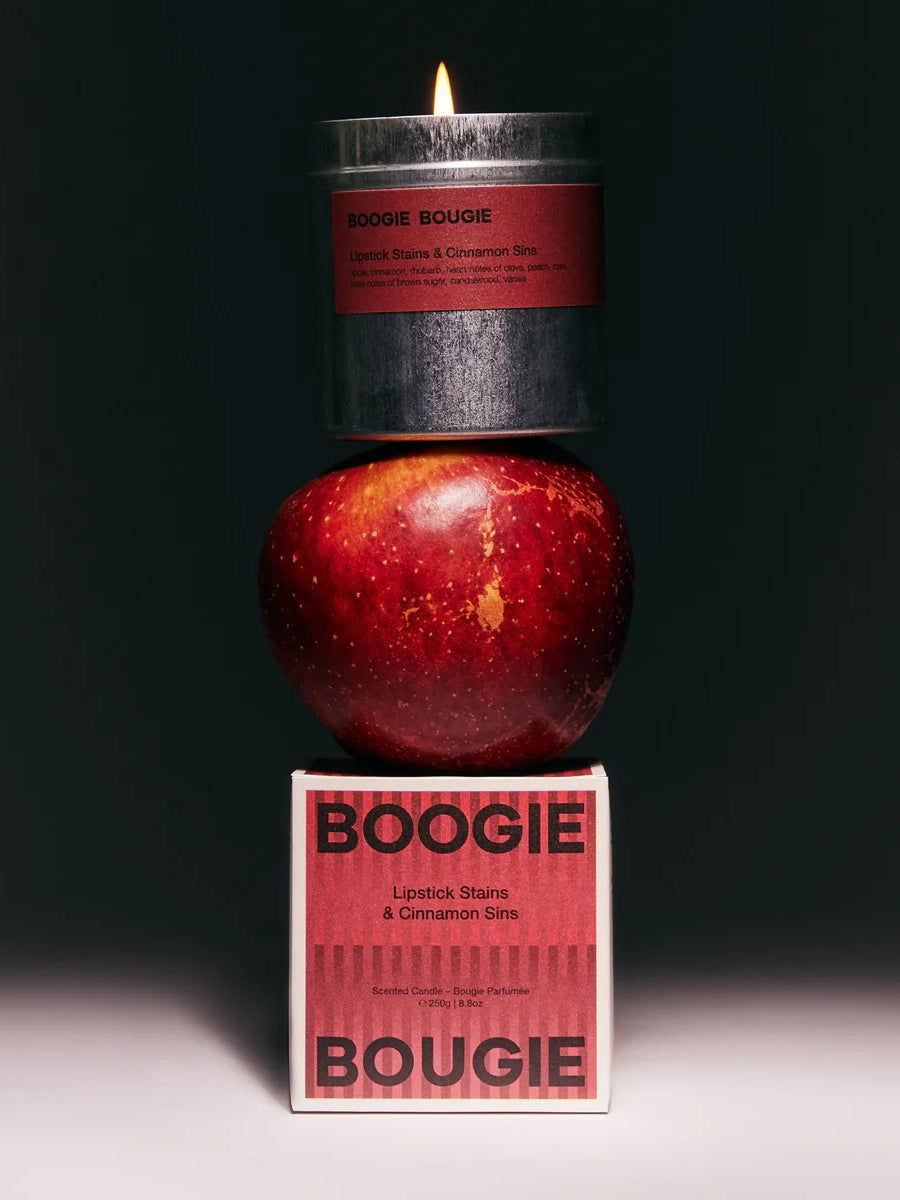 Candle labeled 'Boogie Bougie' with an apple and packaging on a dark background