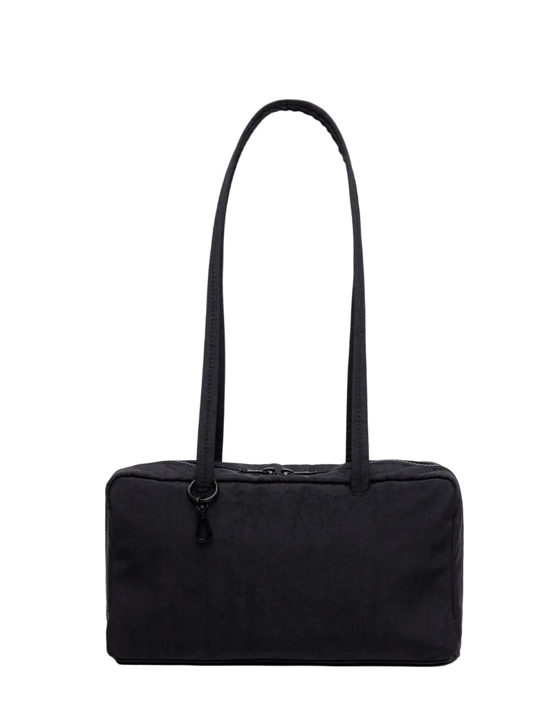 Black handbag with a strap on a light gray background
