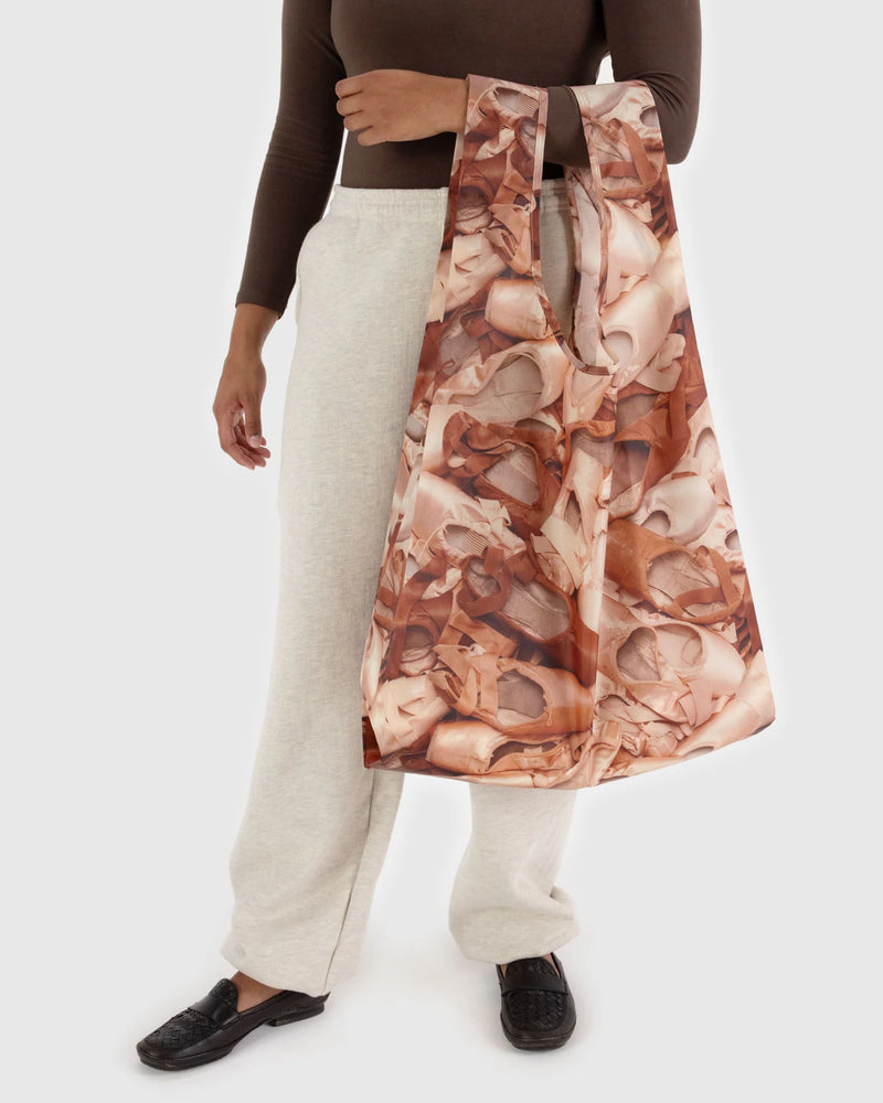 Person holding a patterned bag against a white background