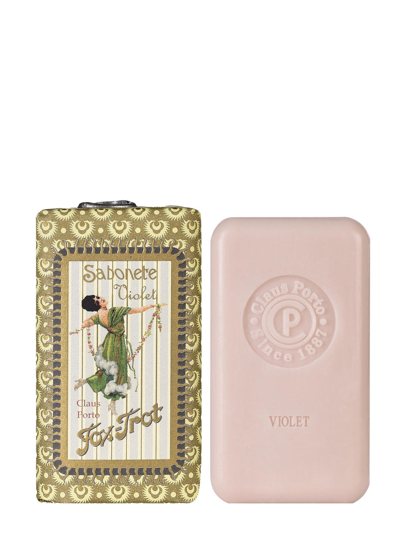 A bar of pink soap with a decorative packaging featuring a woman on a unicorn and the text 'Fox Trot Violet'. The packaging has a vintage-like design with a golden border and 'Claus Porto' branding.