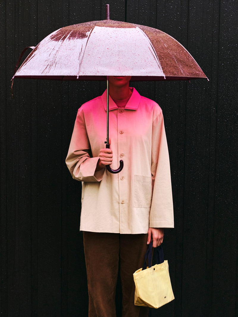 Person holding a vintage-style umbrella against a black background