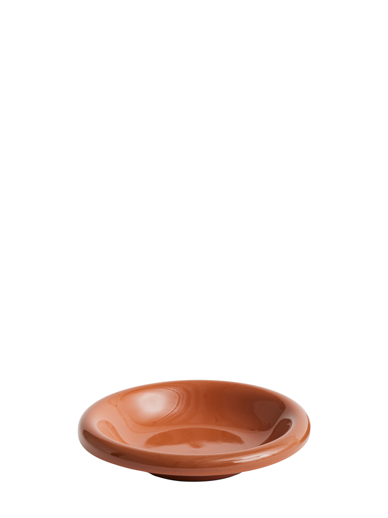 A natural terracotta bowl with a raised edge on a plain background.