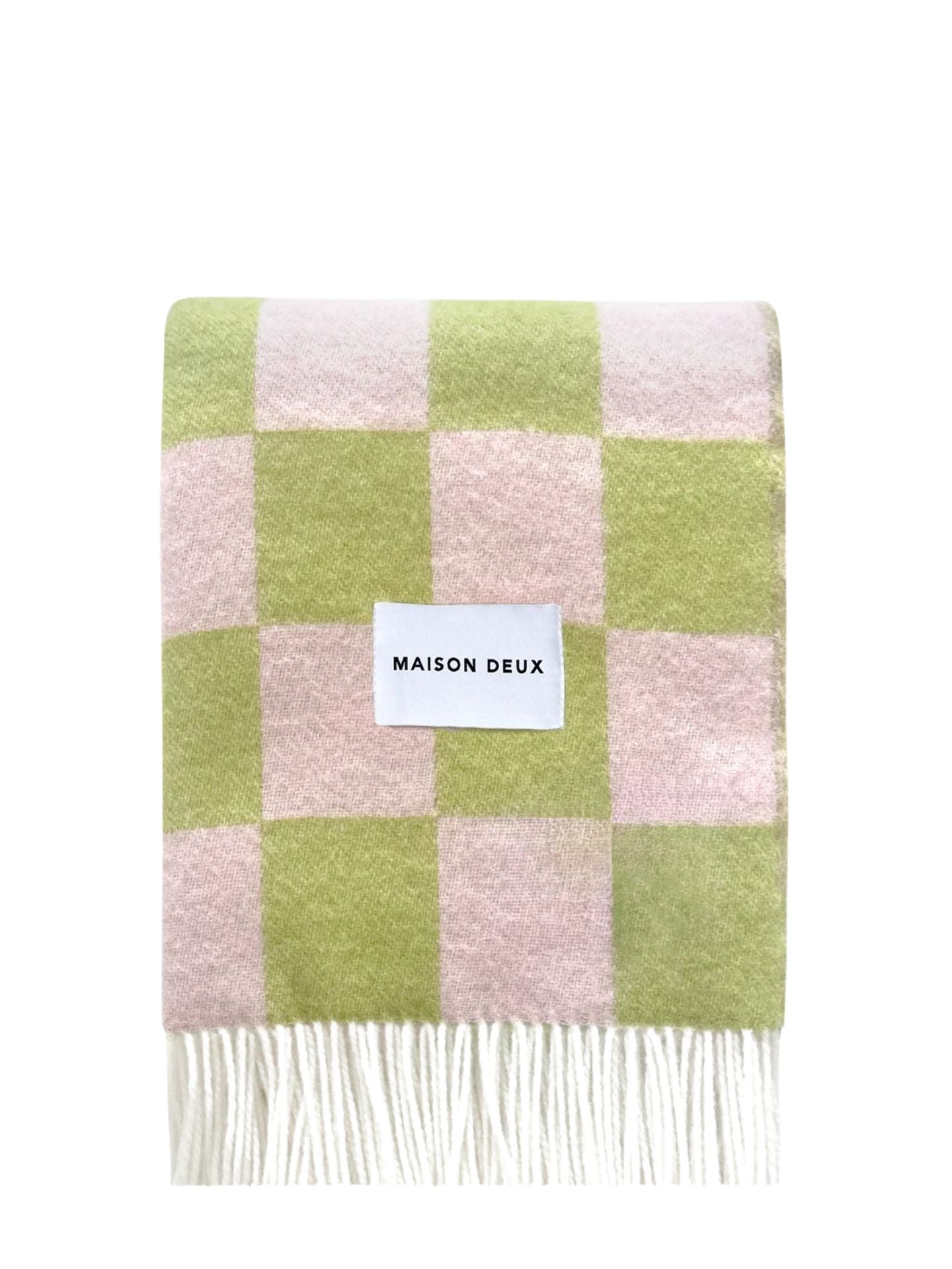 Checkered blanket with pink and green squares and 'Maison Deux' label on a white background
