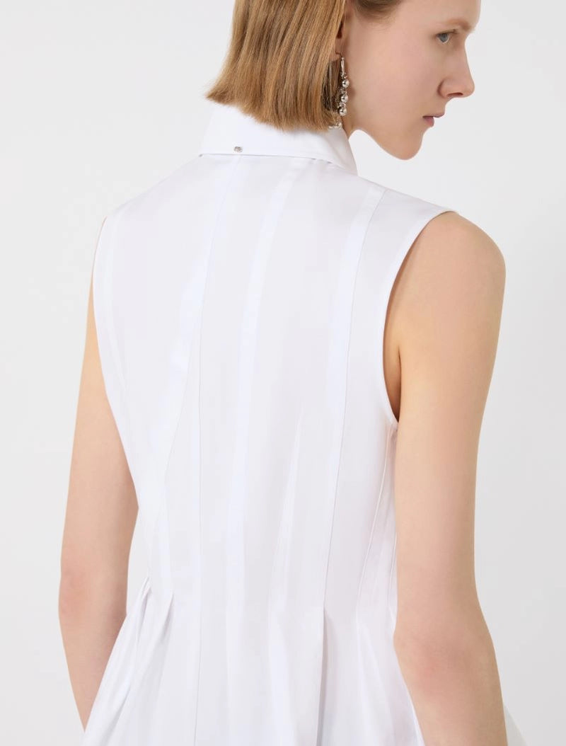 White sleeveless top worn by a person on a white background