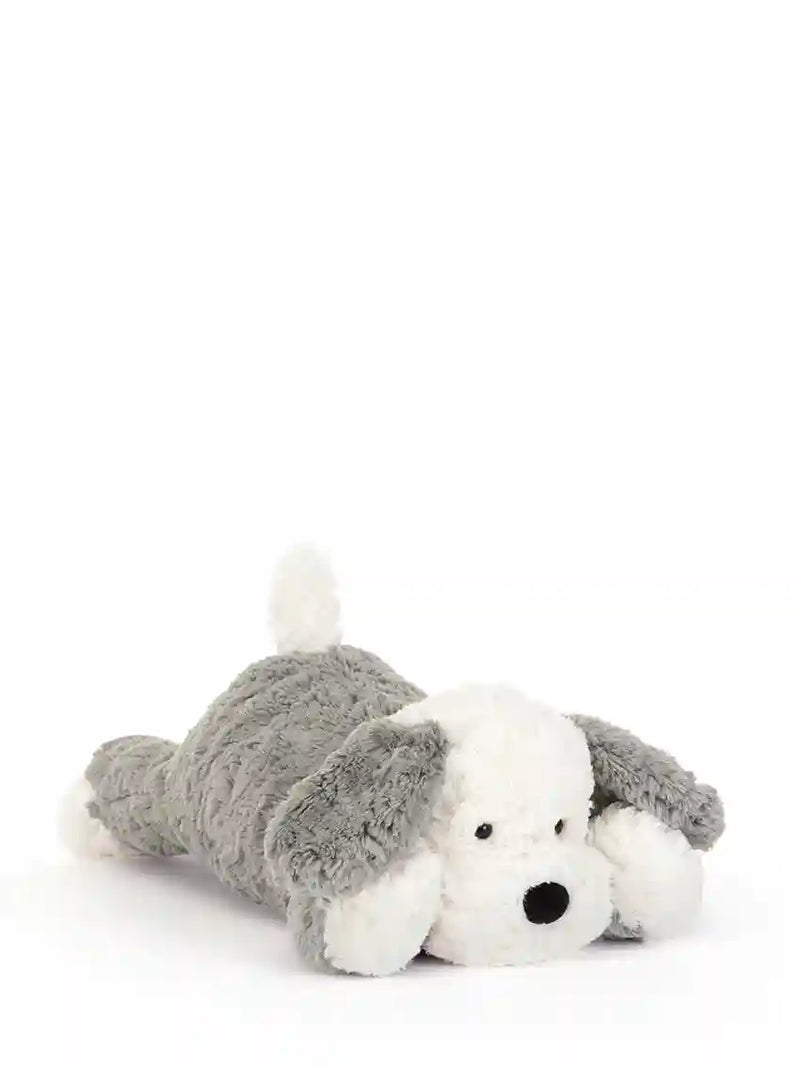 A plush dog toy lying on its side, featuring a soft gray body with floppy ears and a white face, paws, and tail, set against a plain white background.
