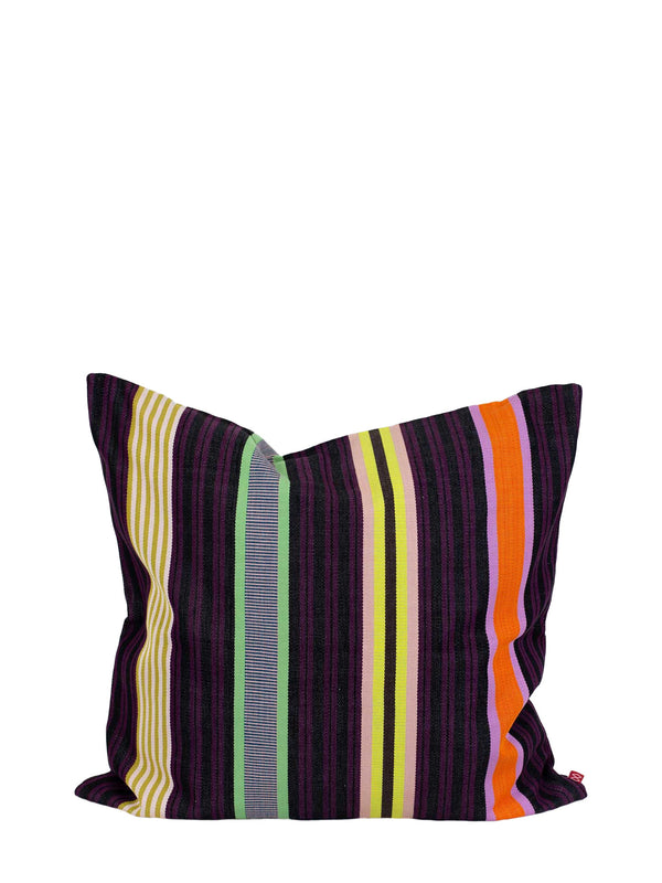 A square throw pillow with a vibrant multicolor striped pattern featuring on base of dark purple and dark wine red, thin and wide stripes in lemon yellow, grass green, olive green, bright orange, magenta, and light soft pink vertical stripes, and a small red brand label on the right seam, shown against a plain white background.