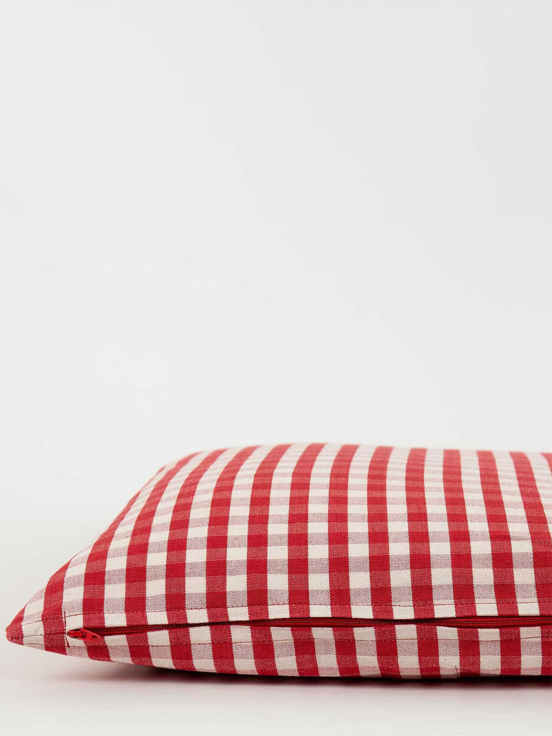 Red and white checkered pillow on a light gray background