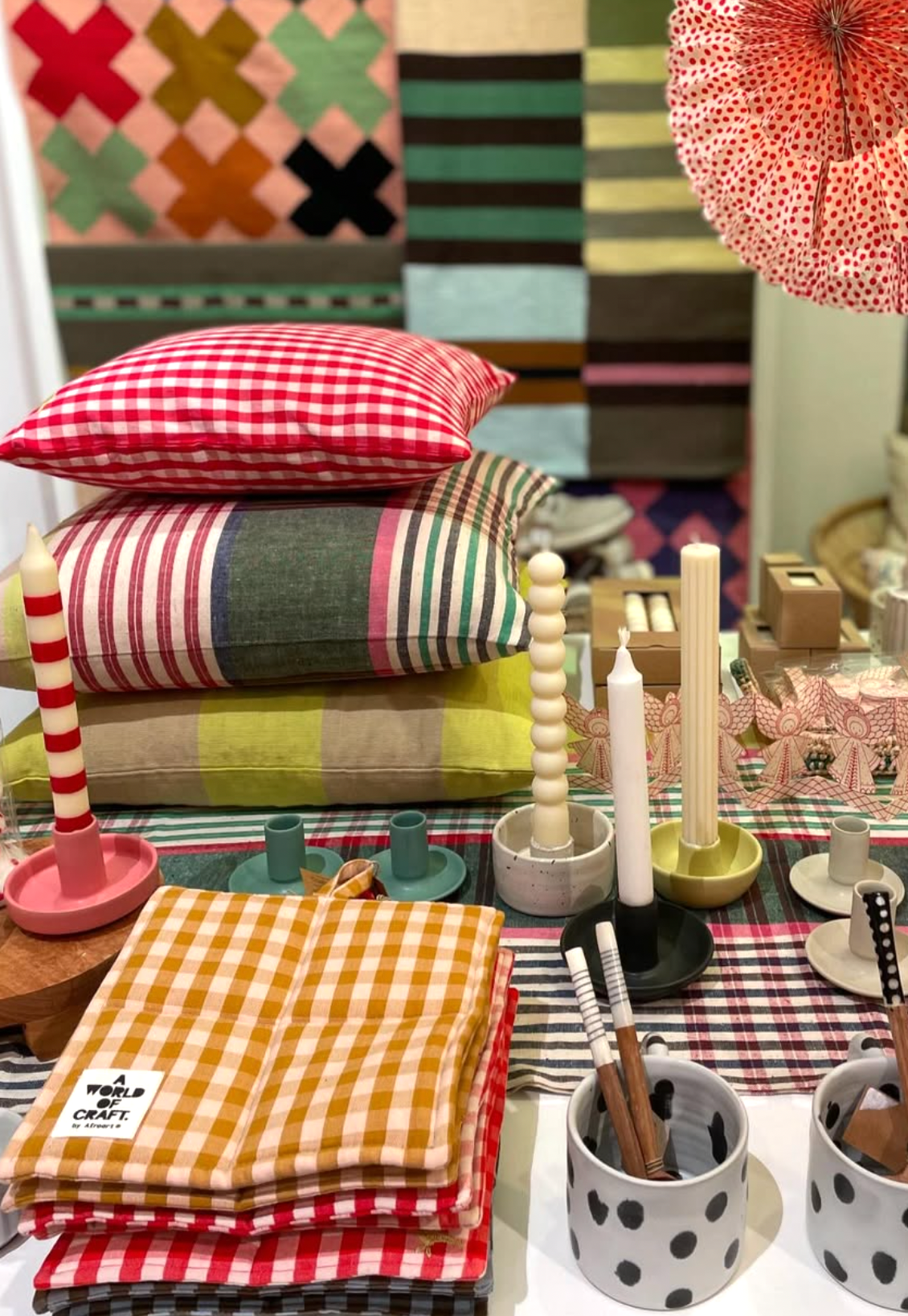 Colorful table setting with checkered napkins, candles, and decorative items.