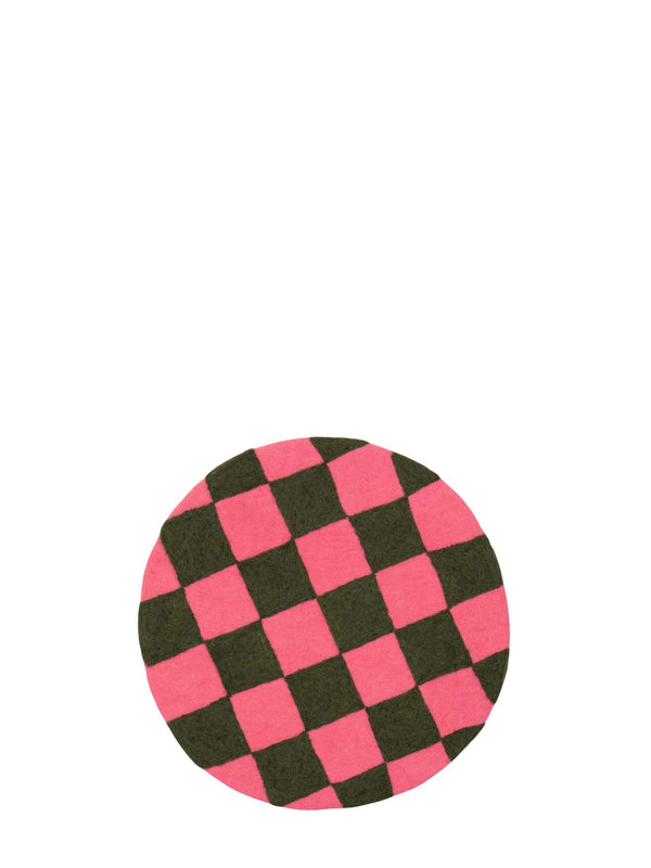 Checkered pink and dark green round seating pad made from felted wool pictured on a white background