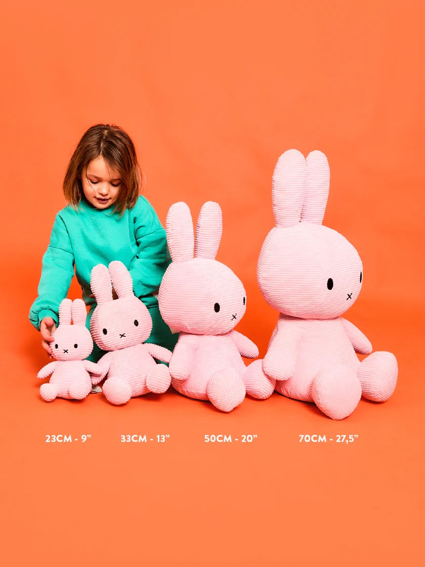 Child with pink plush toys on an orange background