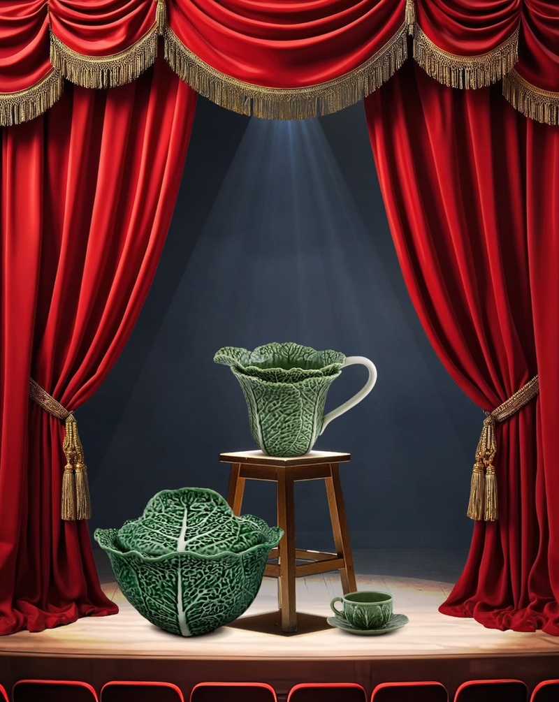 Stage with red curtains, a stool, and green Bordallo Pinheiro cabbage ceramic items
