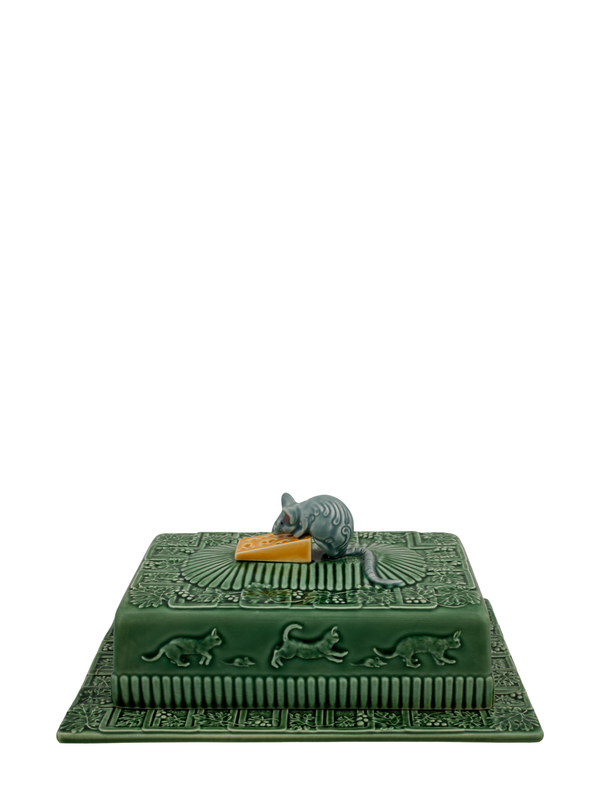 A ceramic cheese tray depicting a green plate with a rectangular lid and a small mouse sitting on the lid, holding a piece of cheese.