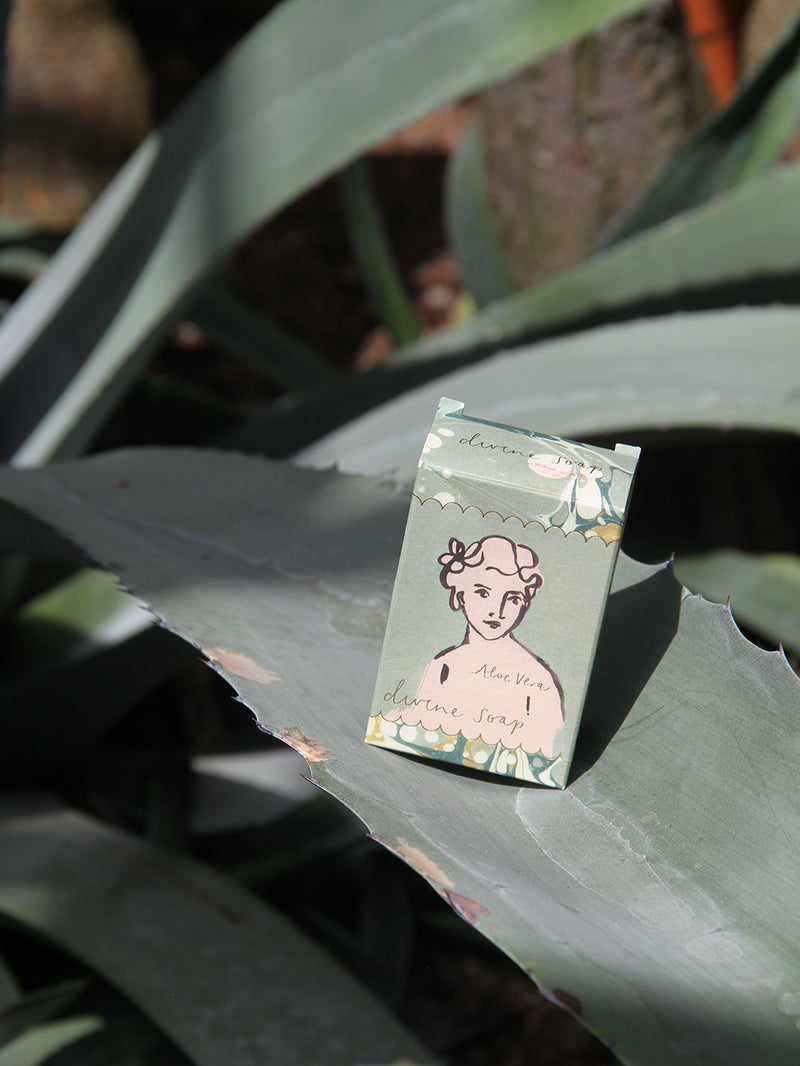 Small bar soap with a woman's face illustration on a leaf