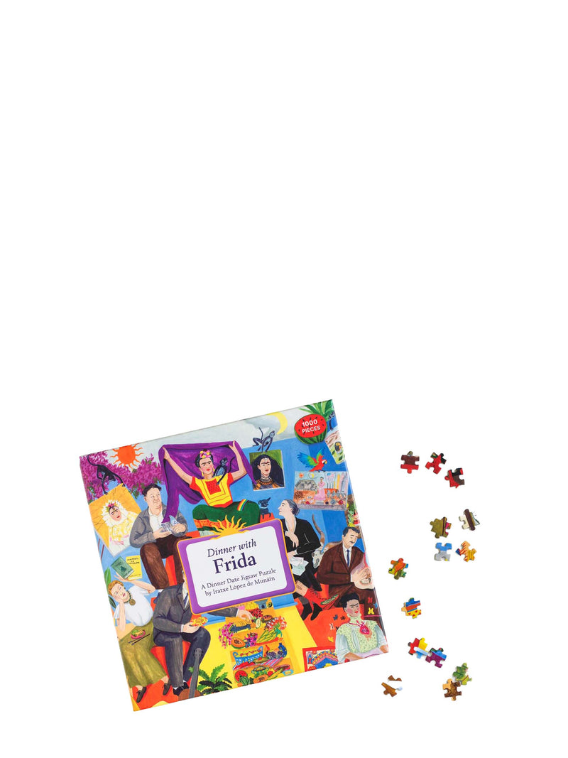 Frida Kahlo puzzle box with colorful illustrations of famous people and scattered puzzle pieces on a white background