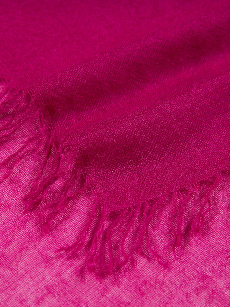 Close-up of a bright pink scarf with frayed edges