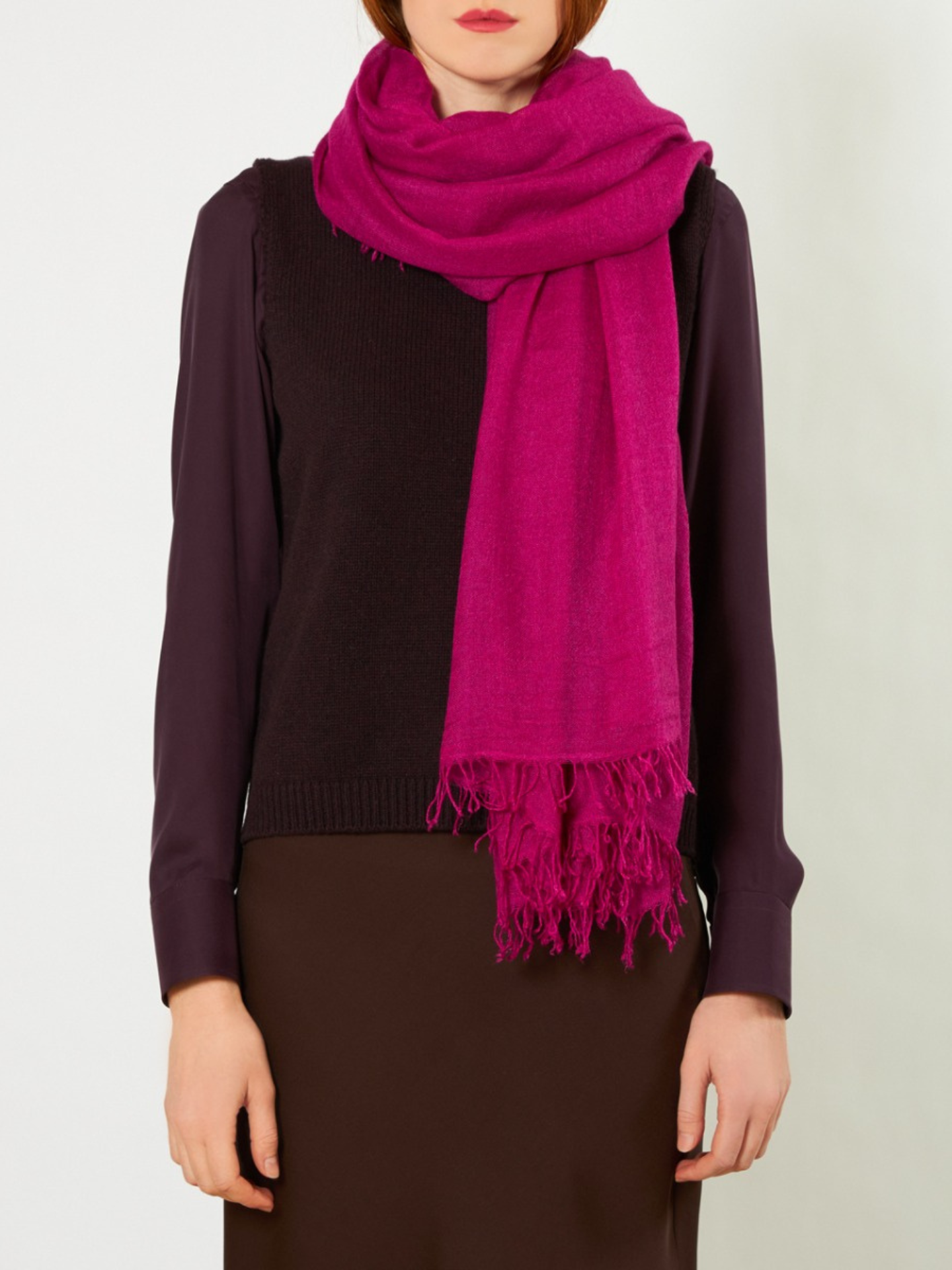 Person wearing a bright pink scarf on a white background