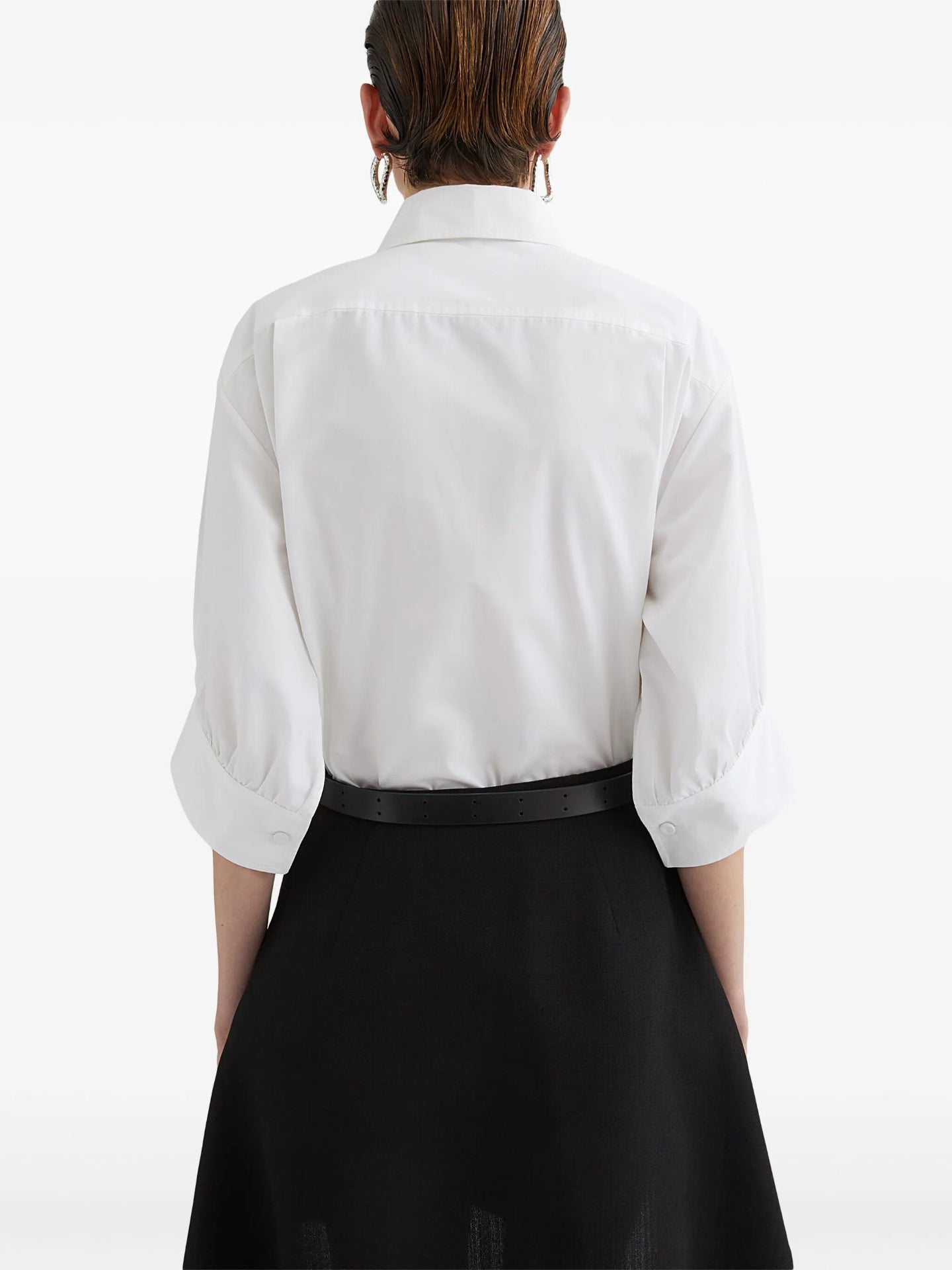 Person wearing a white shirt and black skirt on a white background