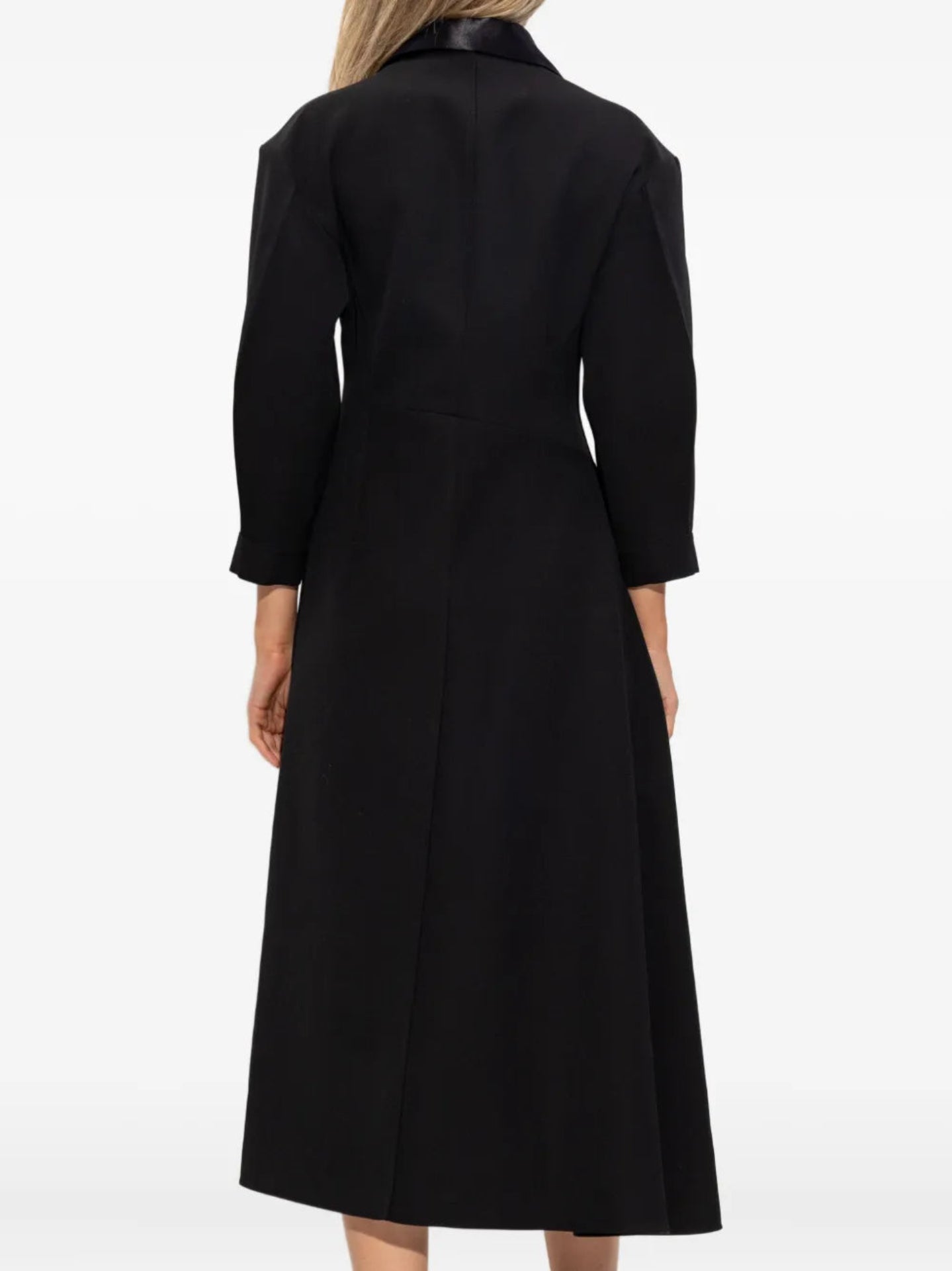 Black coat worn by a person on a white background