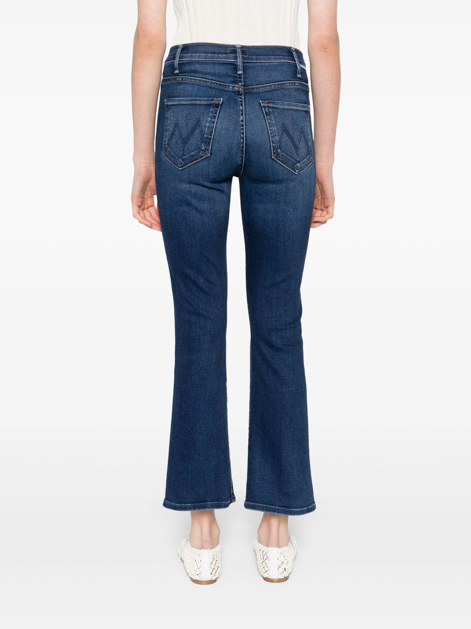 Person wearing blue jeans on a white background