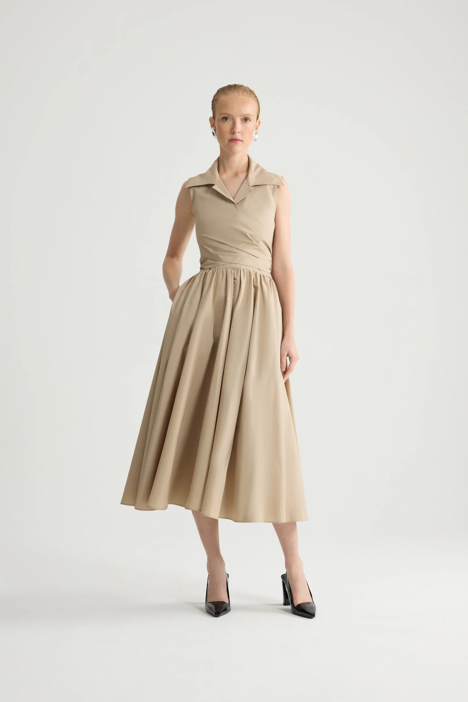 Woman wearing a beige dress on a white background
