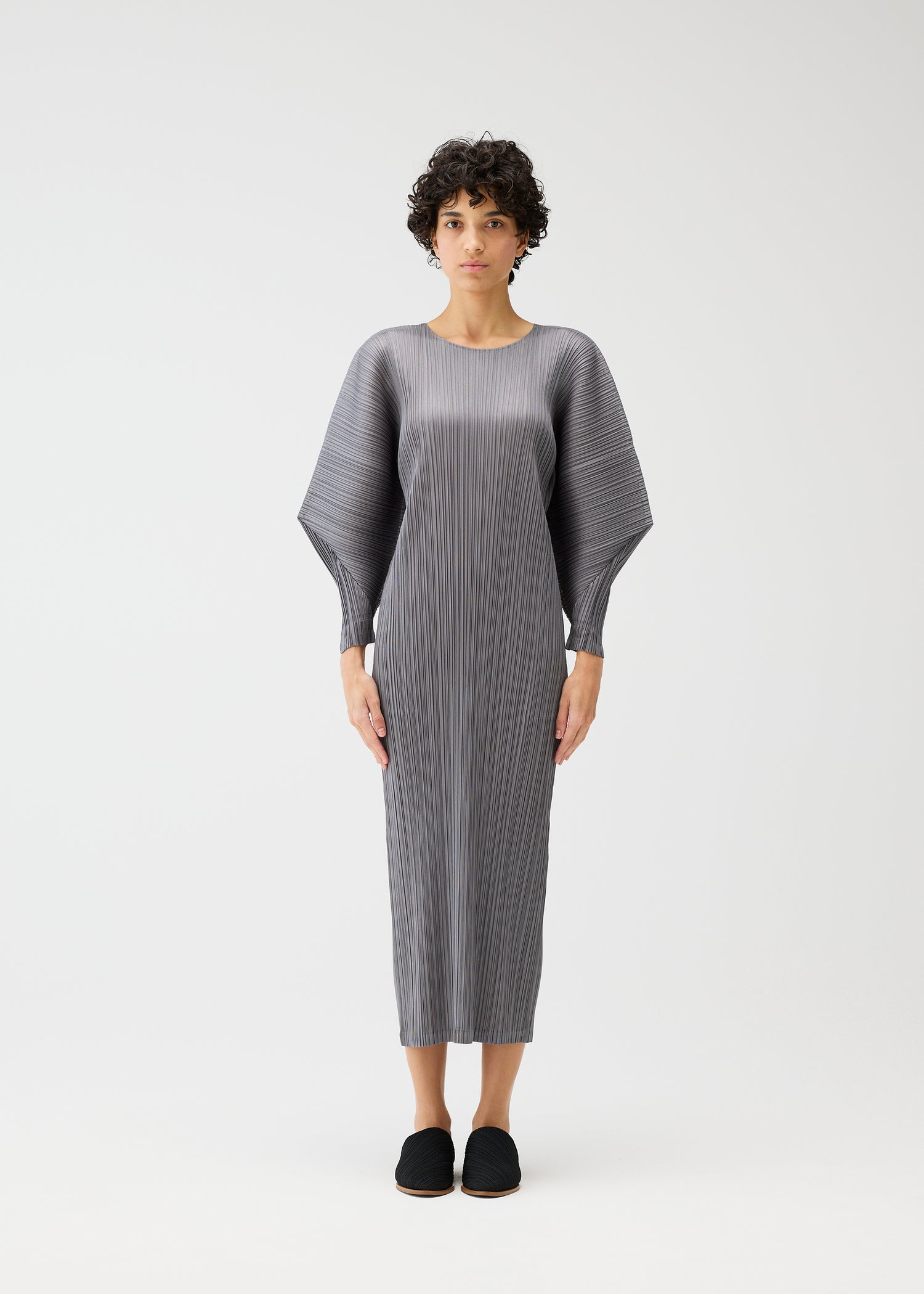 Person wearing a gray dress with a white background