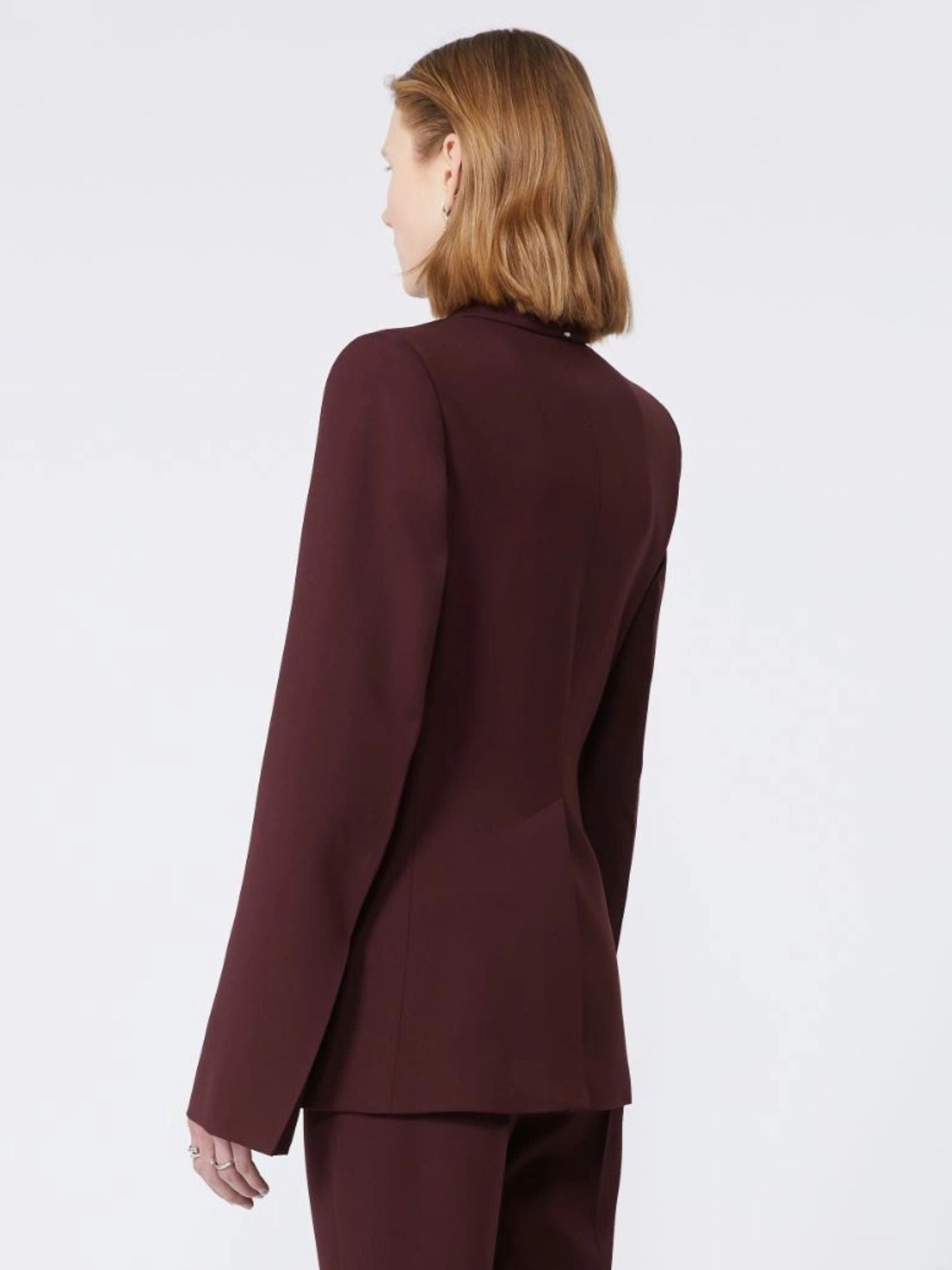 Person wearing a burgundy suit on a white background