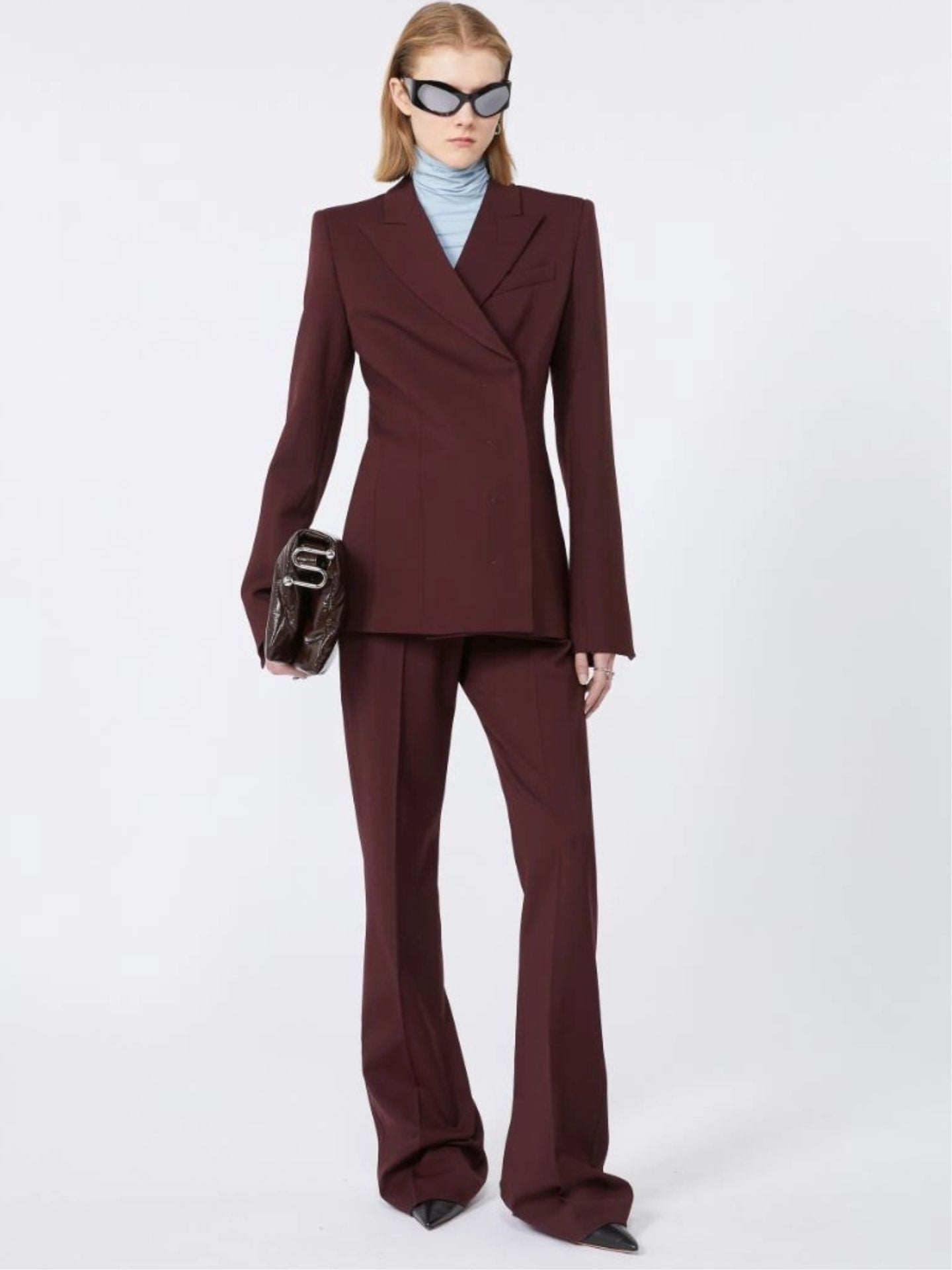 Woman wearing a burgundy suit with a white background