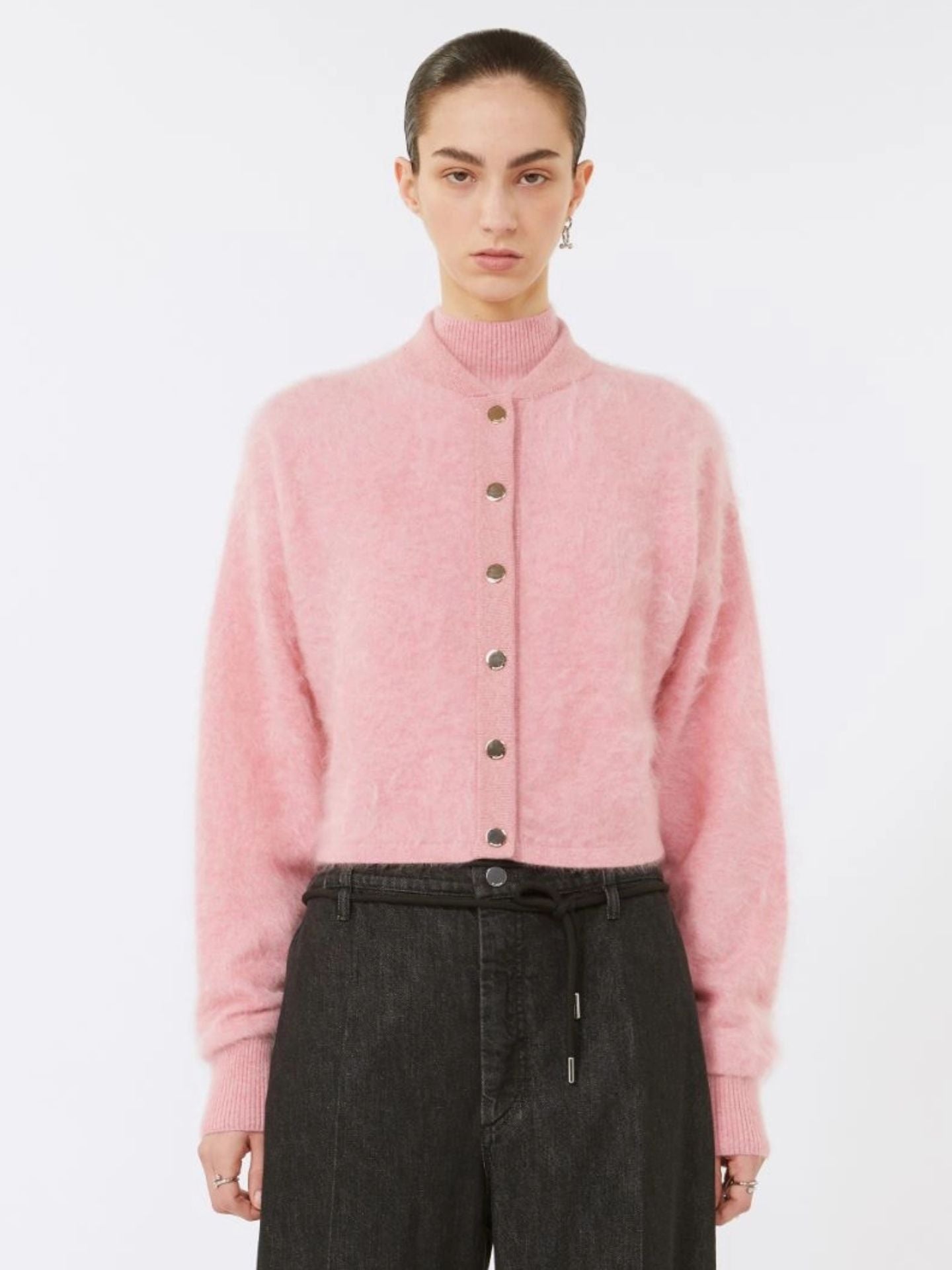 Person wearing a pink cardigan with a white background