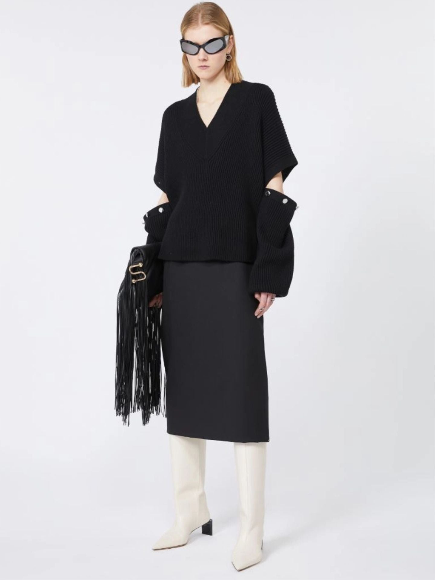 Person wearing a black outfit with white boots on a white background