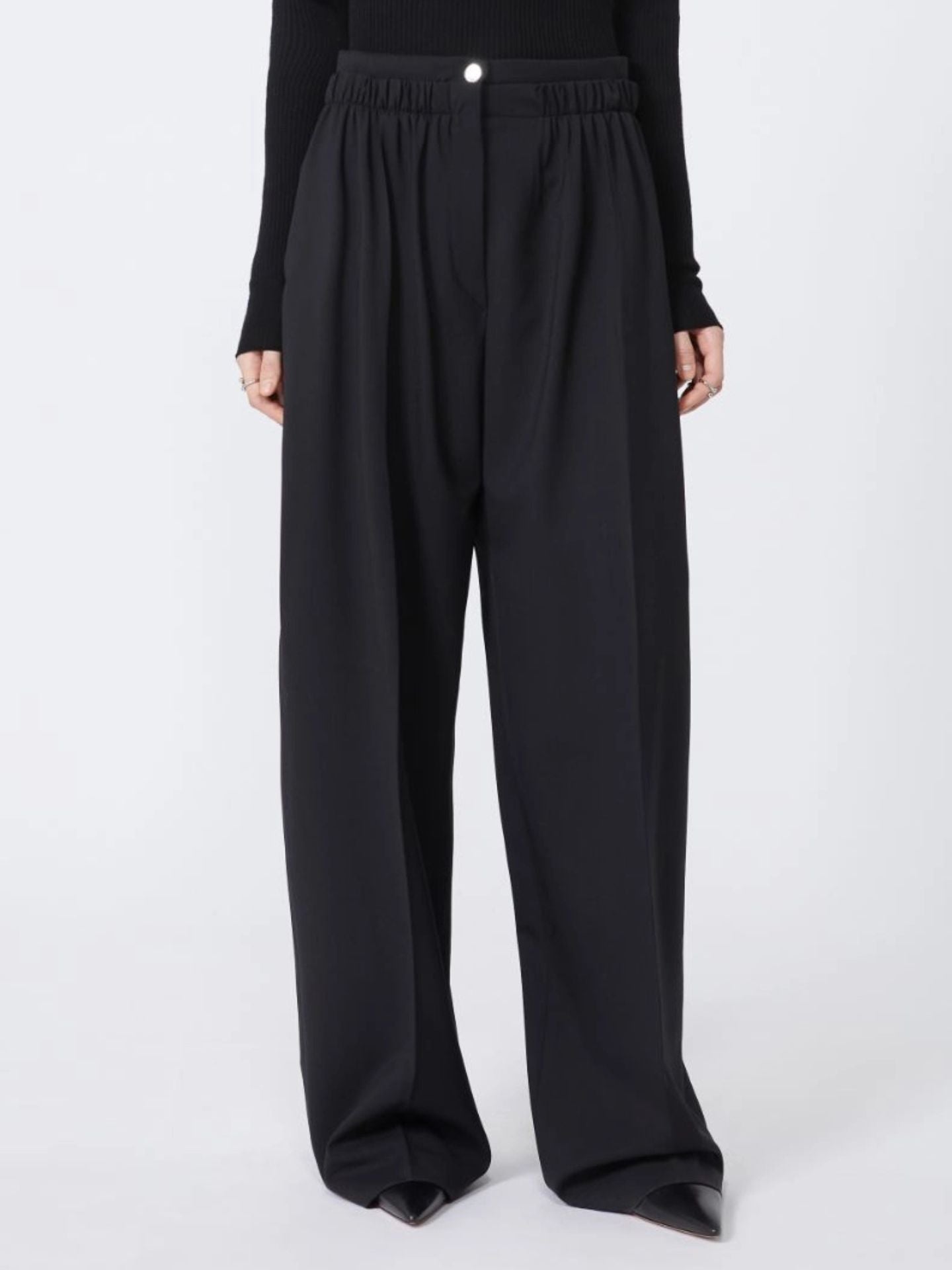 Black wide-leg pants worn by a person on a white background