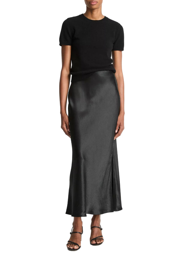 Person wearing a black top and black satin skirt from Vince