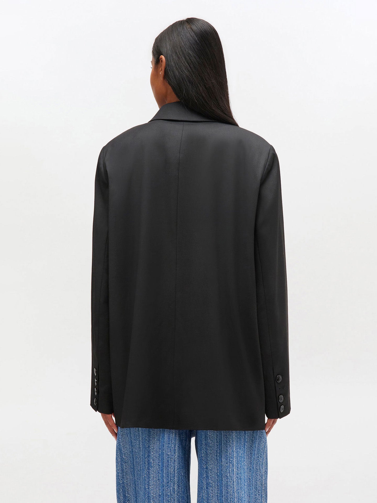 Person wearing a blazer from behind on a white background