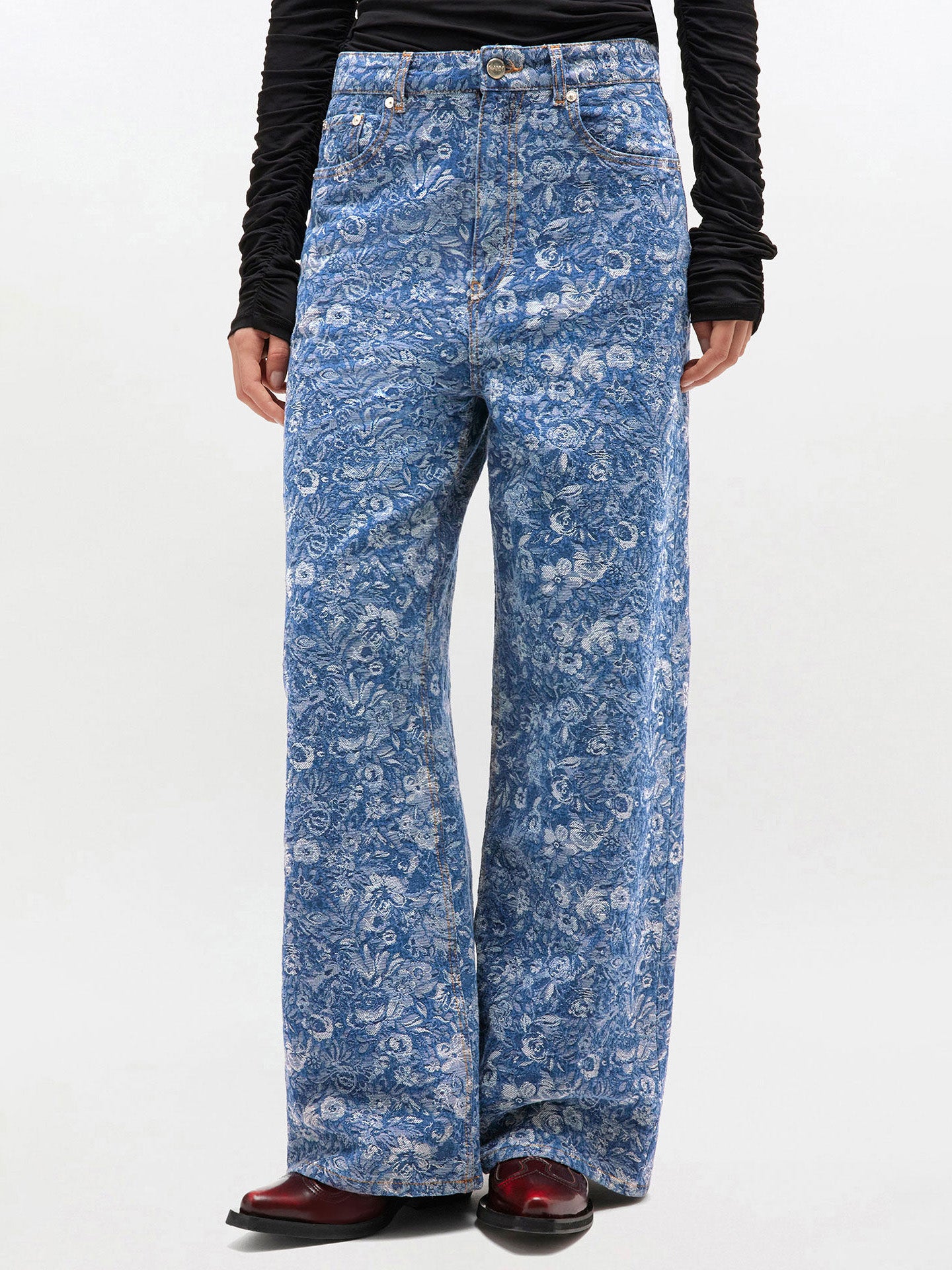 Blue floral-patterned jeans worn by a person on a white background
