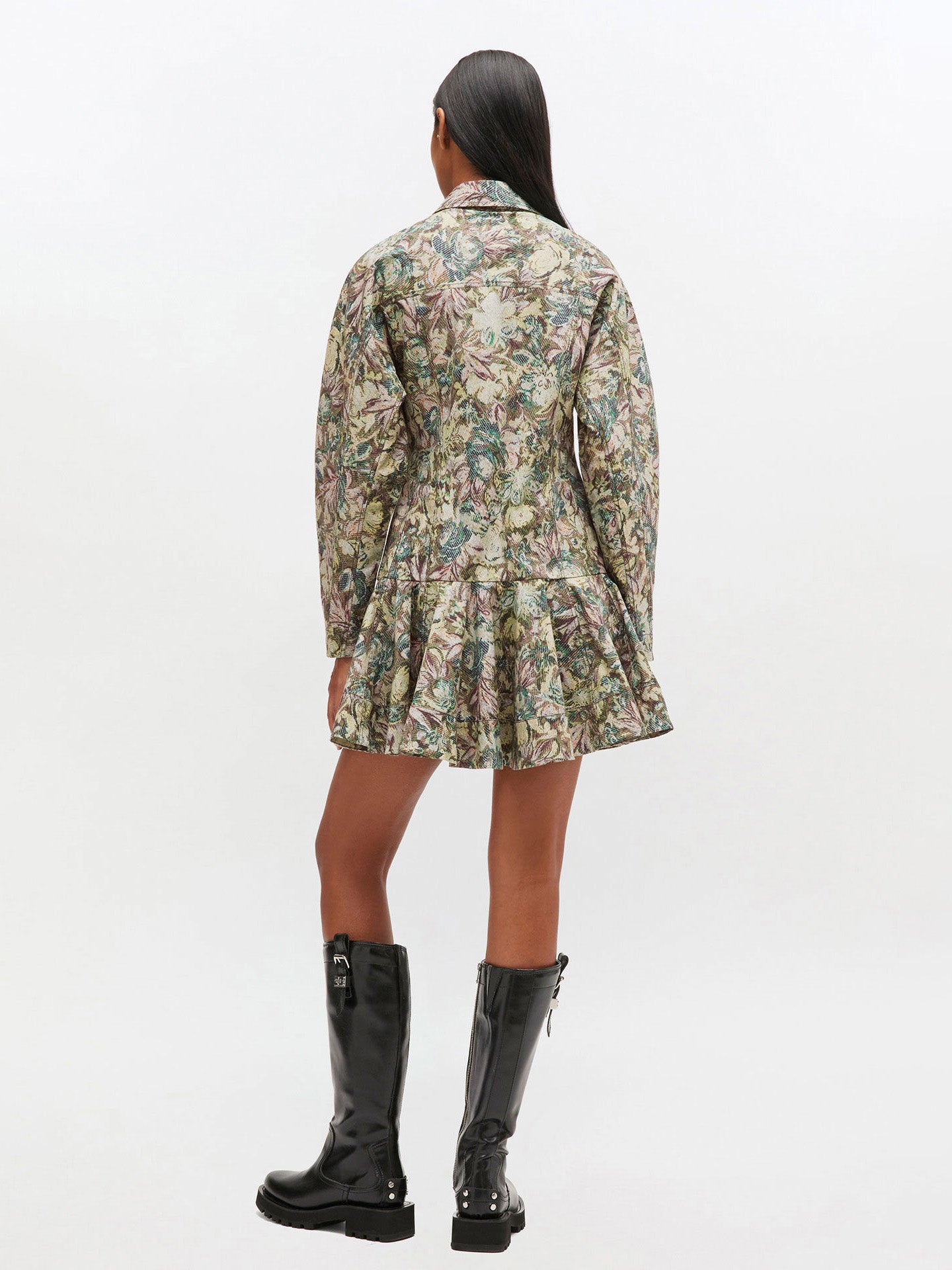 Person wearing a floral dress and black boots on a white background