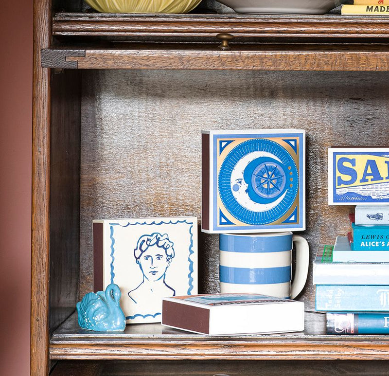 Wooden shelf with decorative items including a mug, books, and small boxes.