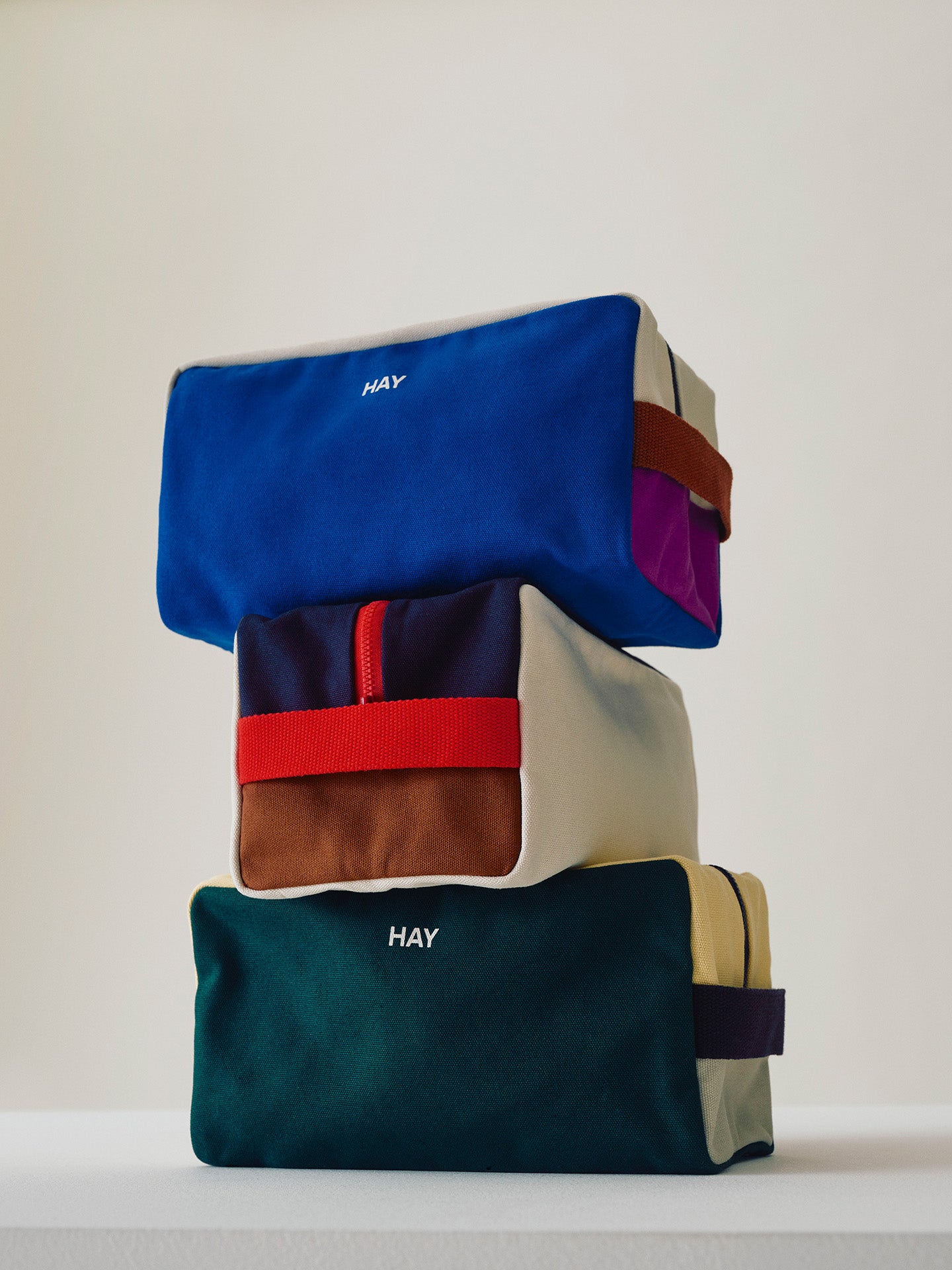 Stack of colorful bags with 'HAY' branding on a light background