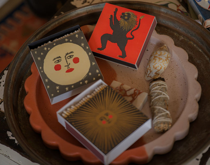 Three small boxes with decorative designs on a textured surface