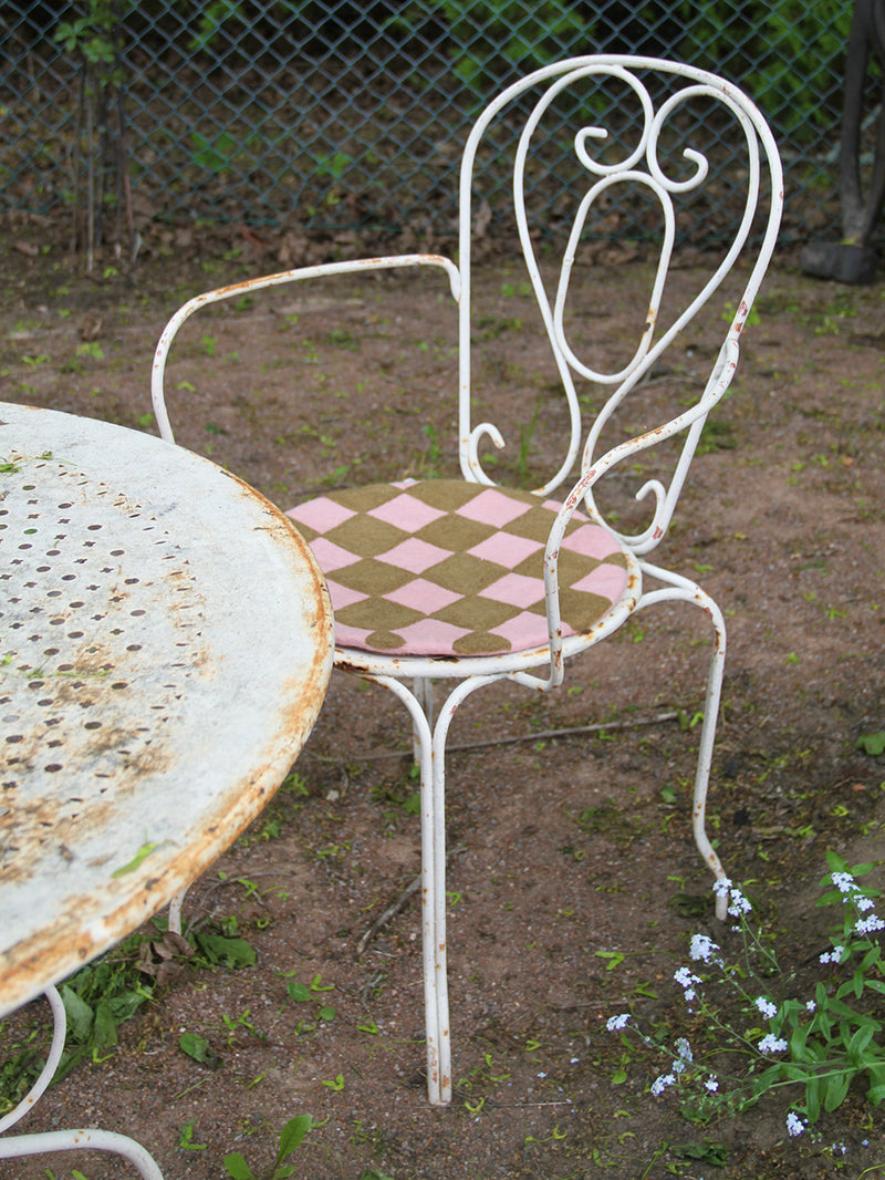 Vintage metal chair with a checkered seat on a garden setting