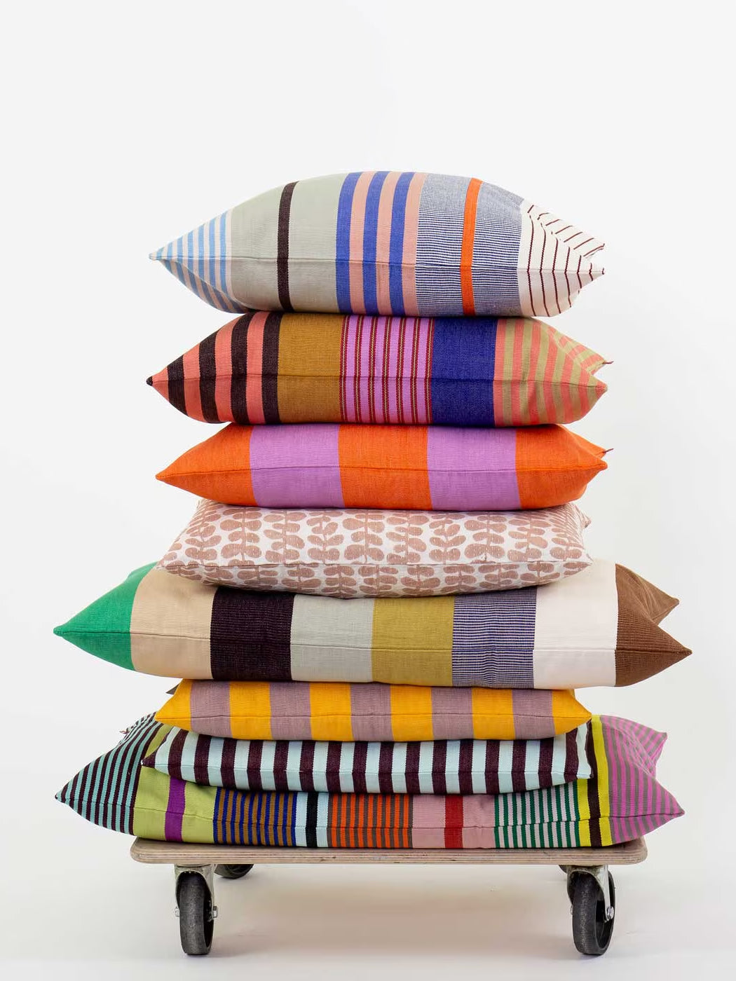 Stack of colorful patterned pillows on a white background