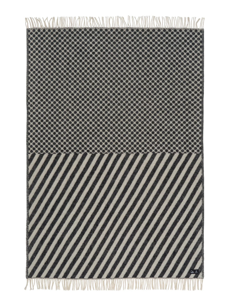 Black and white patterned throw blanket with fringes on a white background