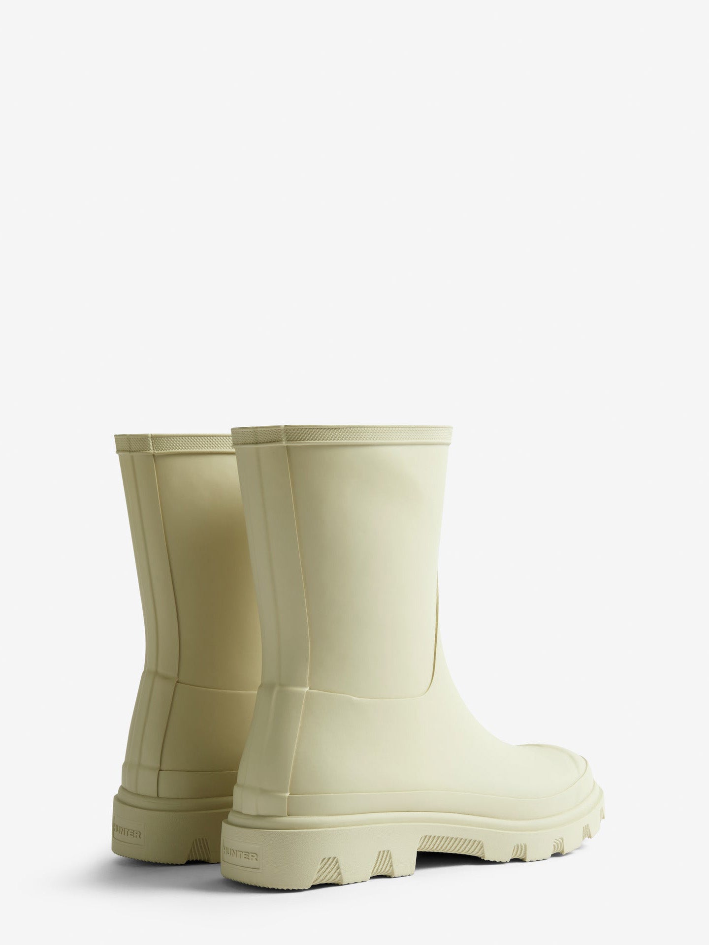 Pair of beige rubber boots on a white background