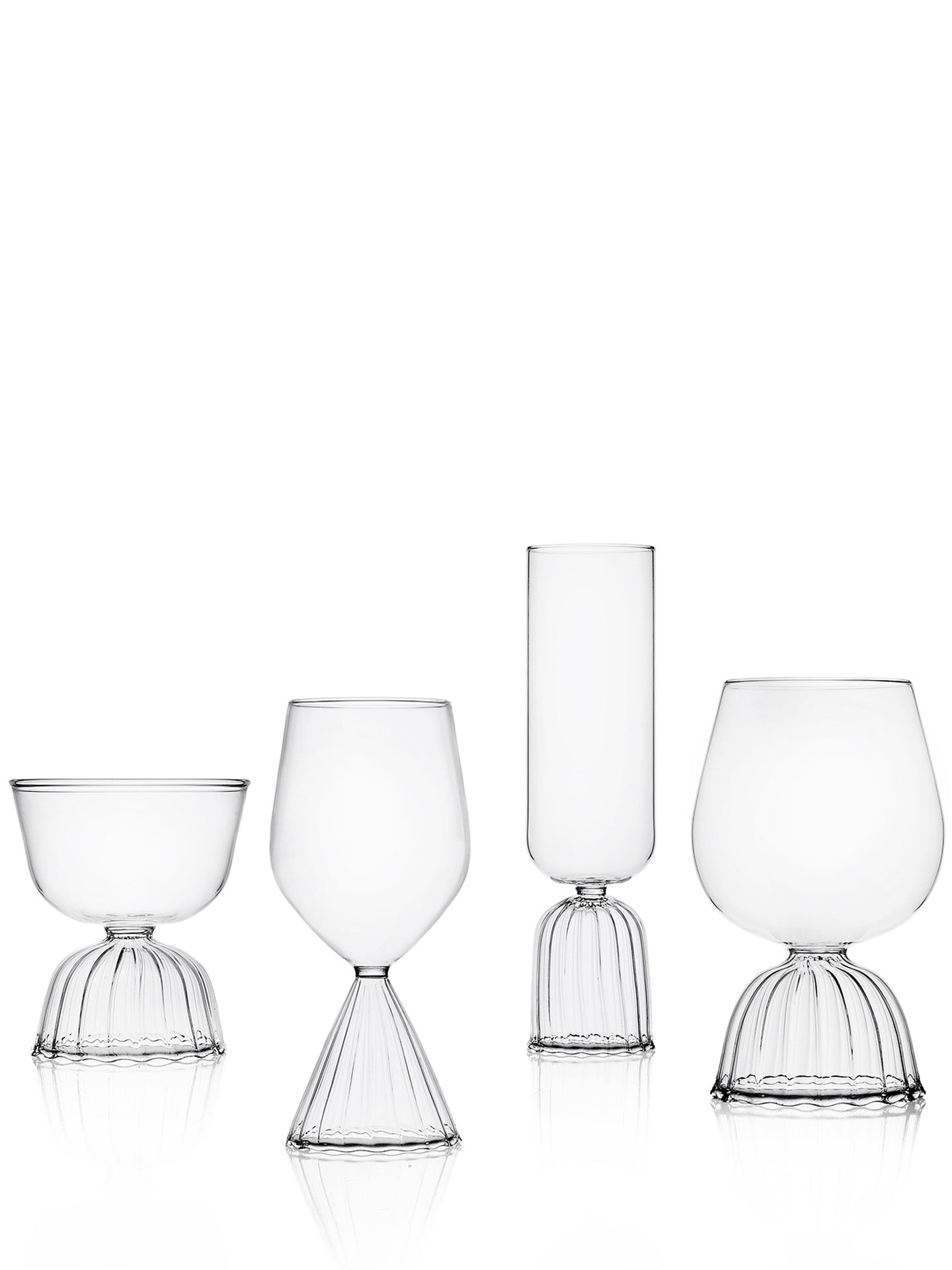 Set of four clear glass tumblers of different shapes and sizes on a white background.